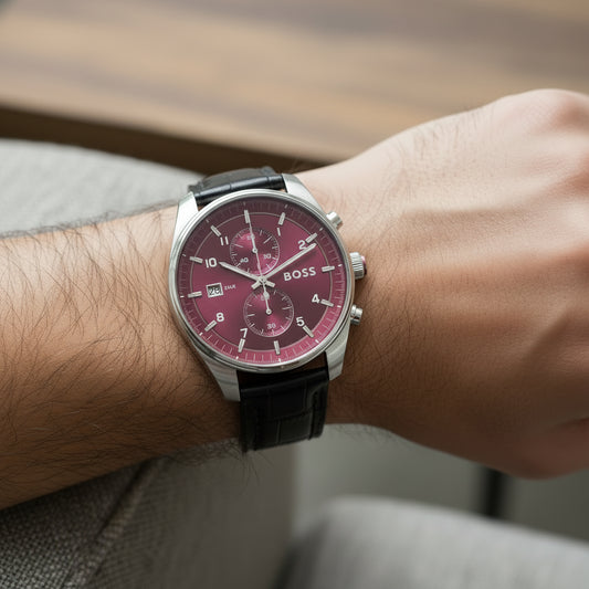 A Hugo Boss wristwatch with a silver-tone case, a deep red dial with three subdials, and a black alligator-patterned leather strap.